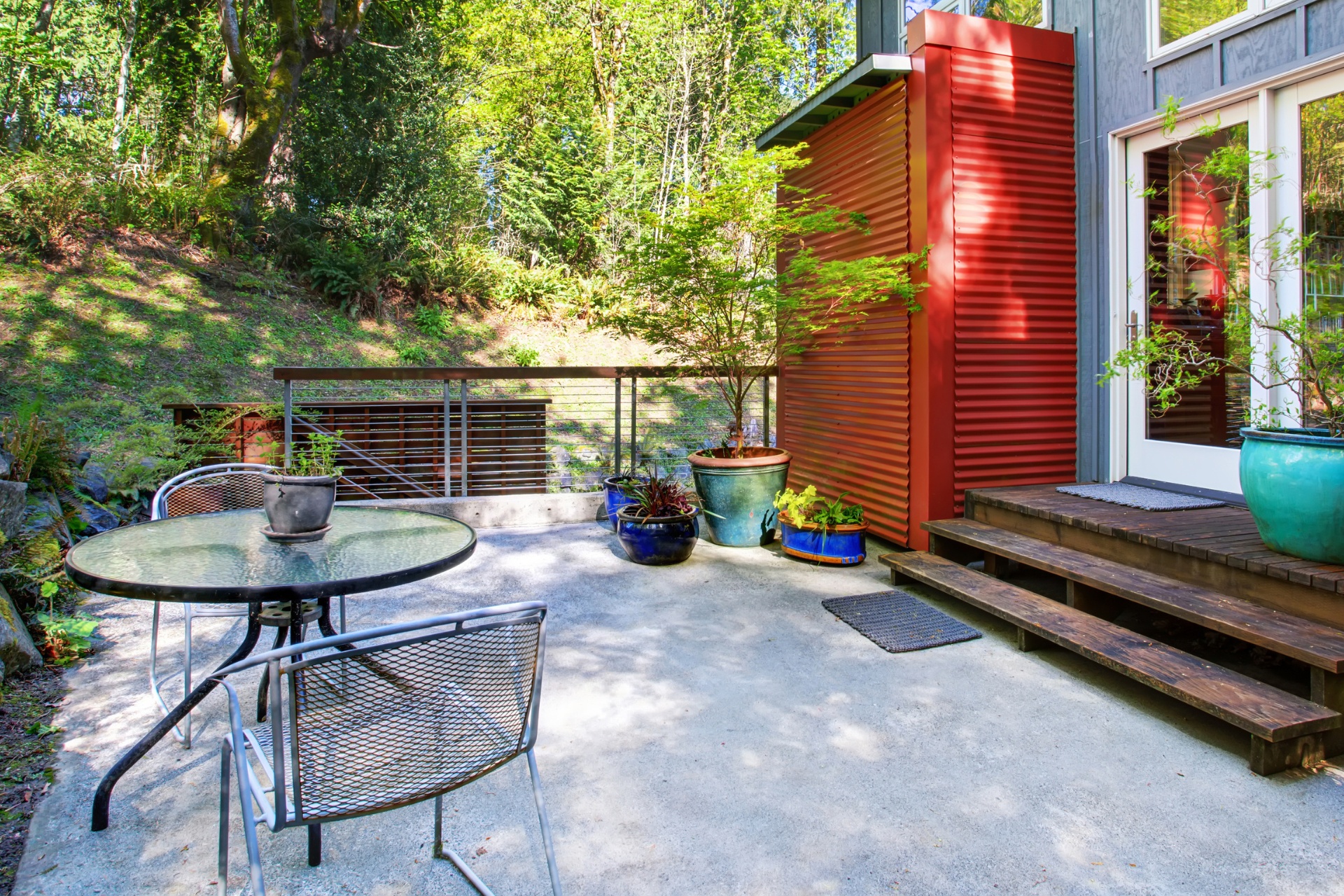 A small backyard concrete patio next to a brightly painted house.
